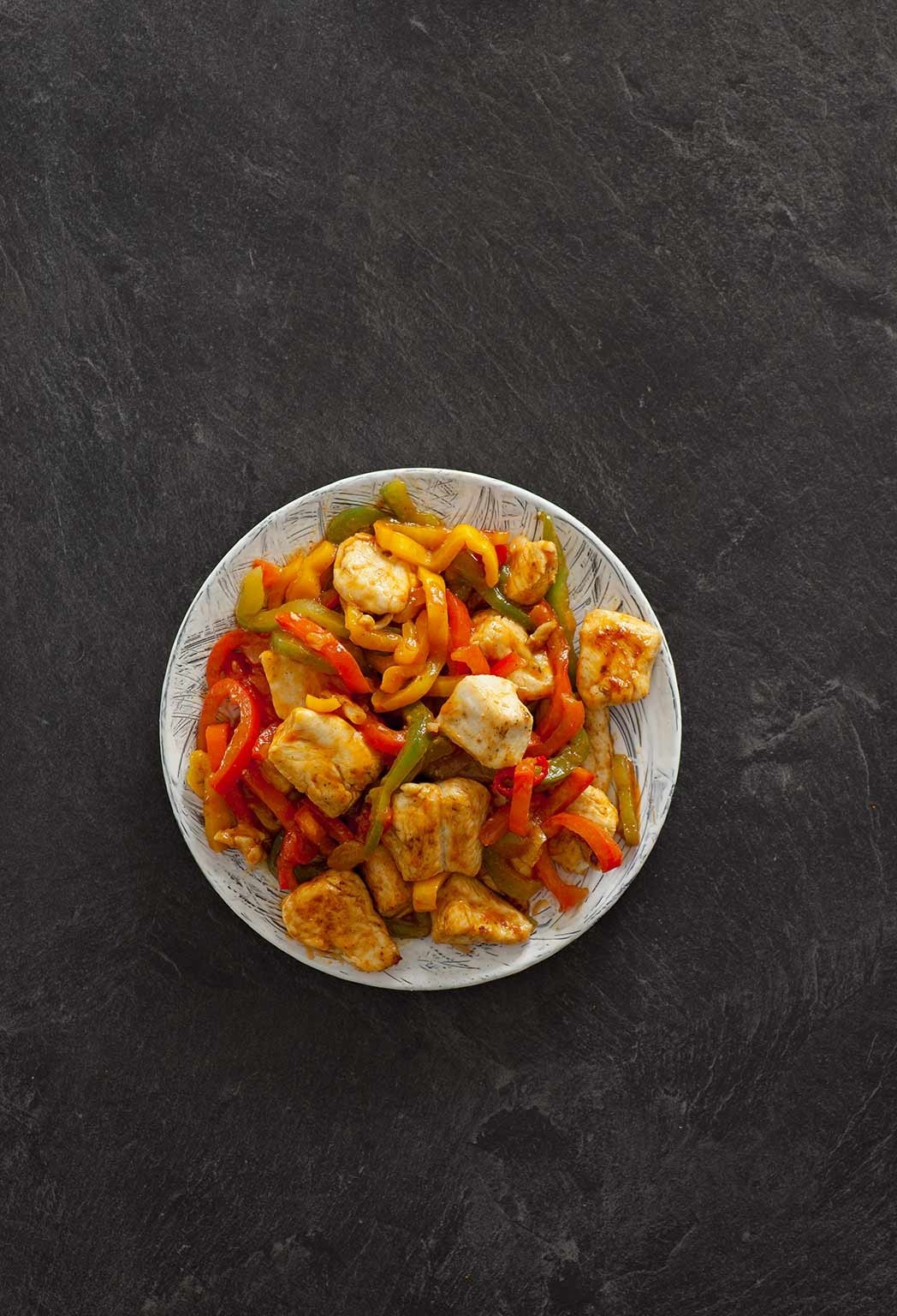 Ein Topf voller aromatisiertes Hähneragout mit Paprika und anderen Gemüse